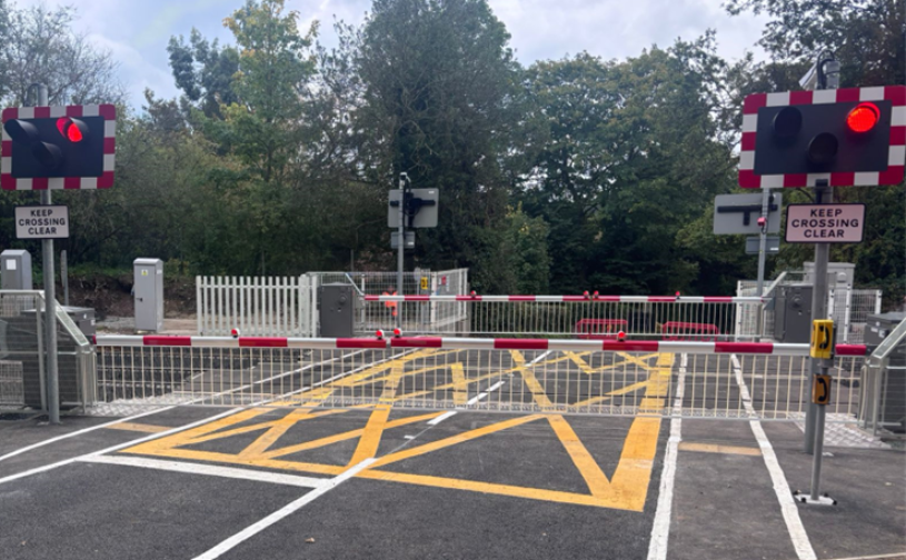 Image showing new and updated Brooks level crossing with barriers down and red signal lights flashing